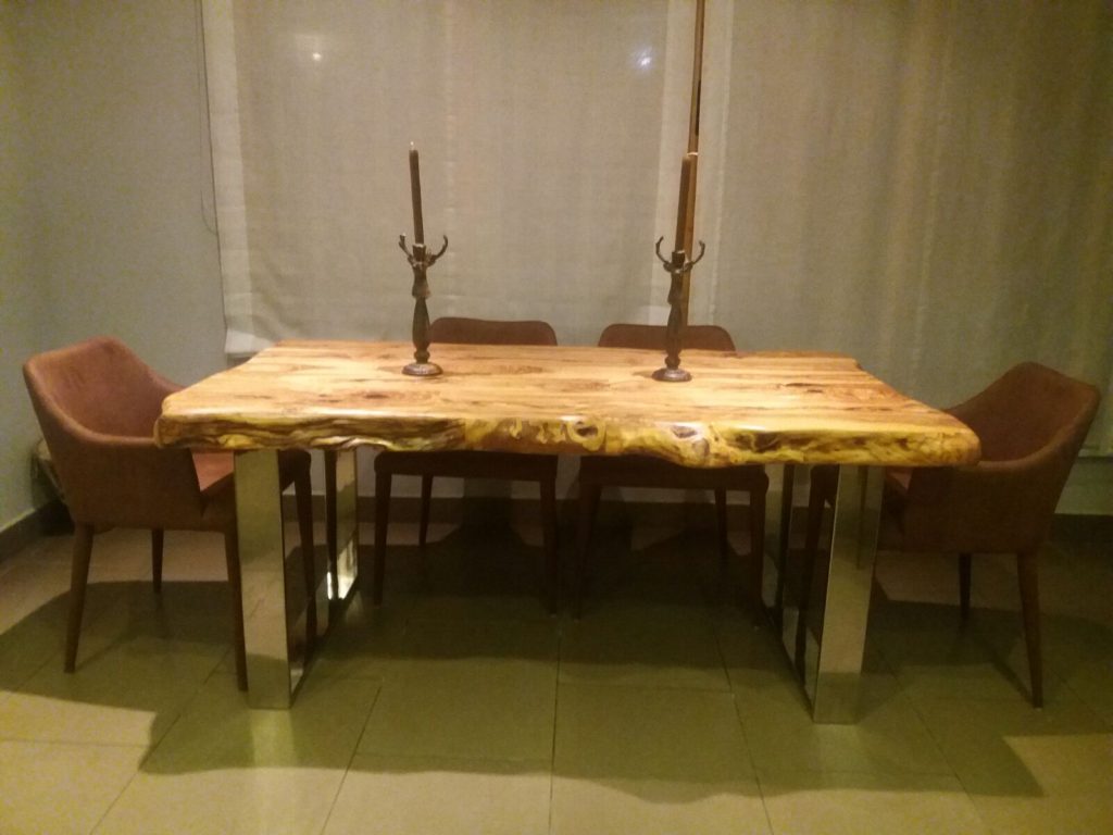 Mesa en madera de olivo y patas de acero inoxidable.
